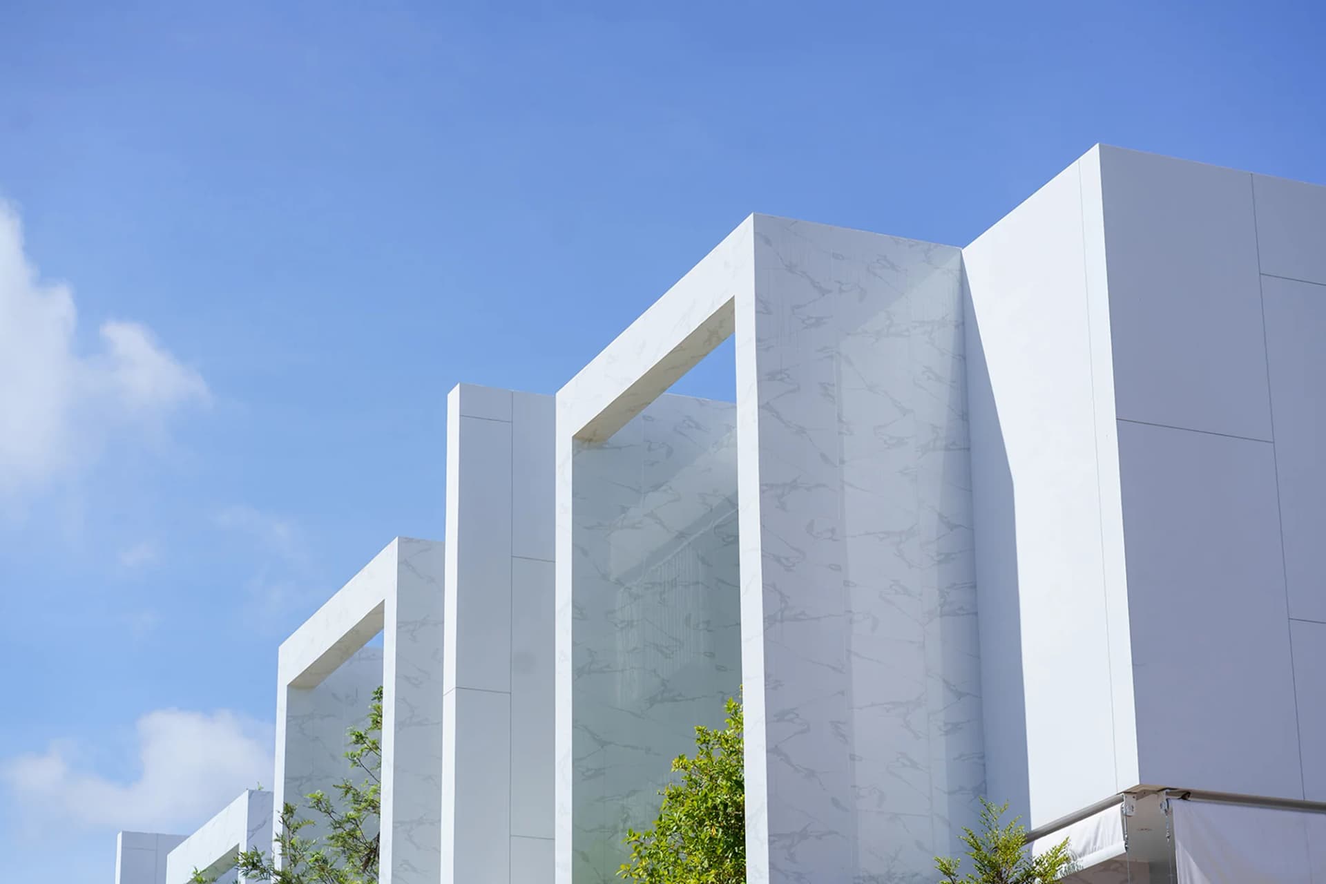 White frames of a finished row of villas against the sky